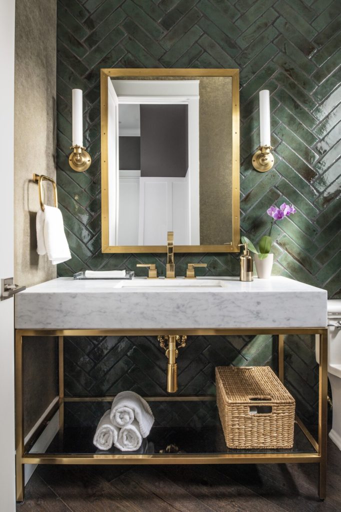 Green tiled powder bath and white counter with sleek golden frame