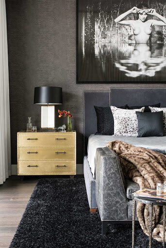 Modern bed, side table with aesthetic wall portrait and black bedroom rug