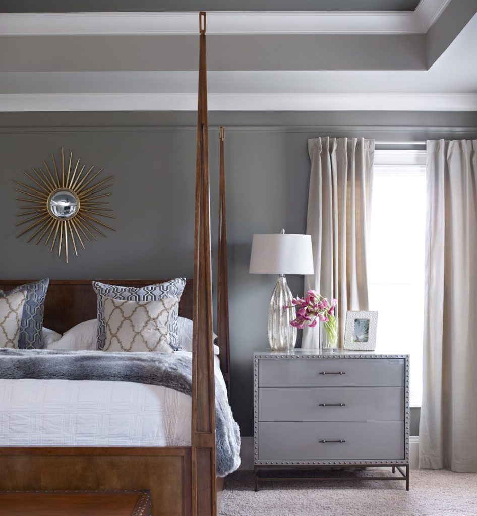Classic wooden bed with sleek white side table and soothing grey wall